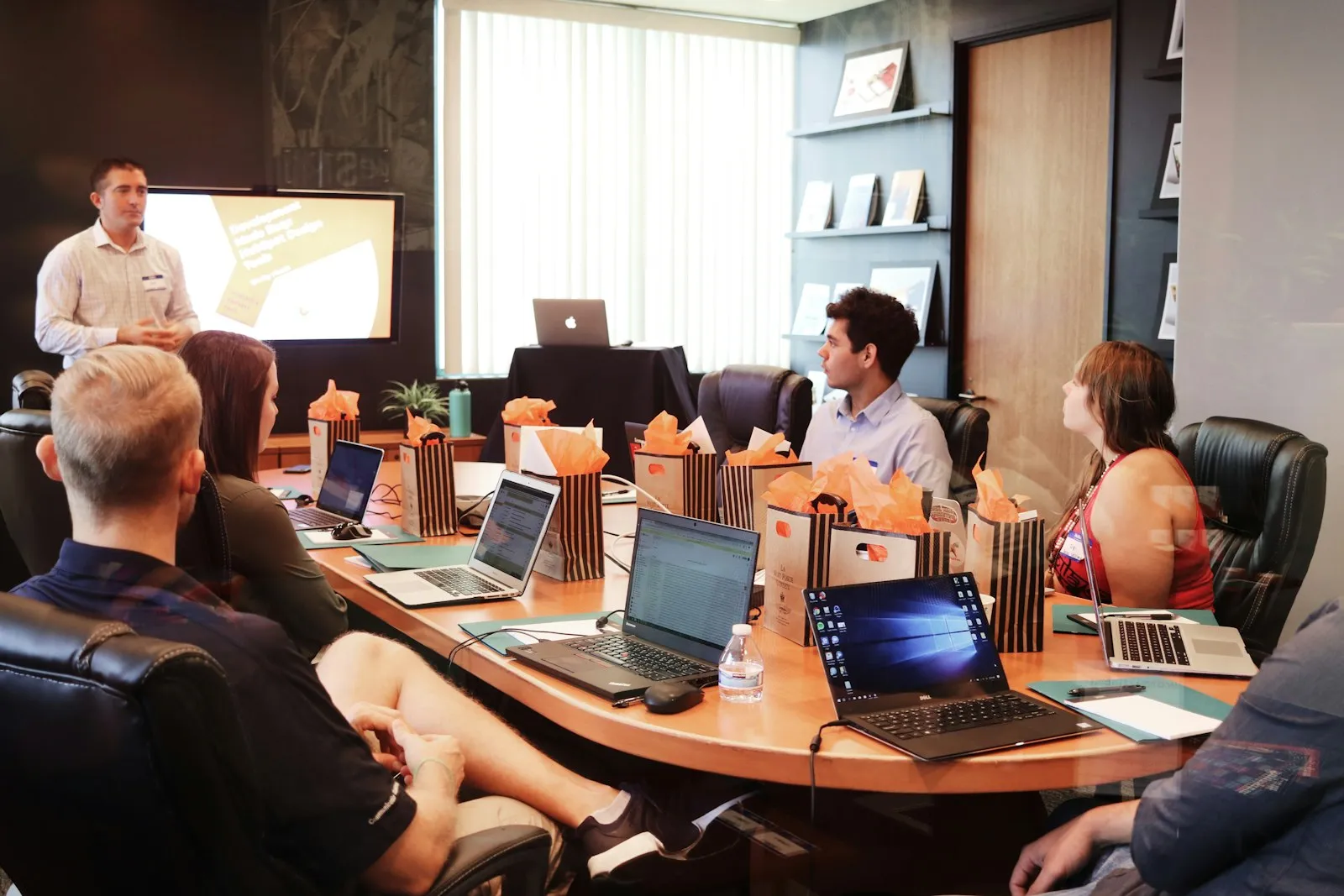 Team in einer Besprechung am Konferenztisch mit Laptops