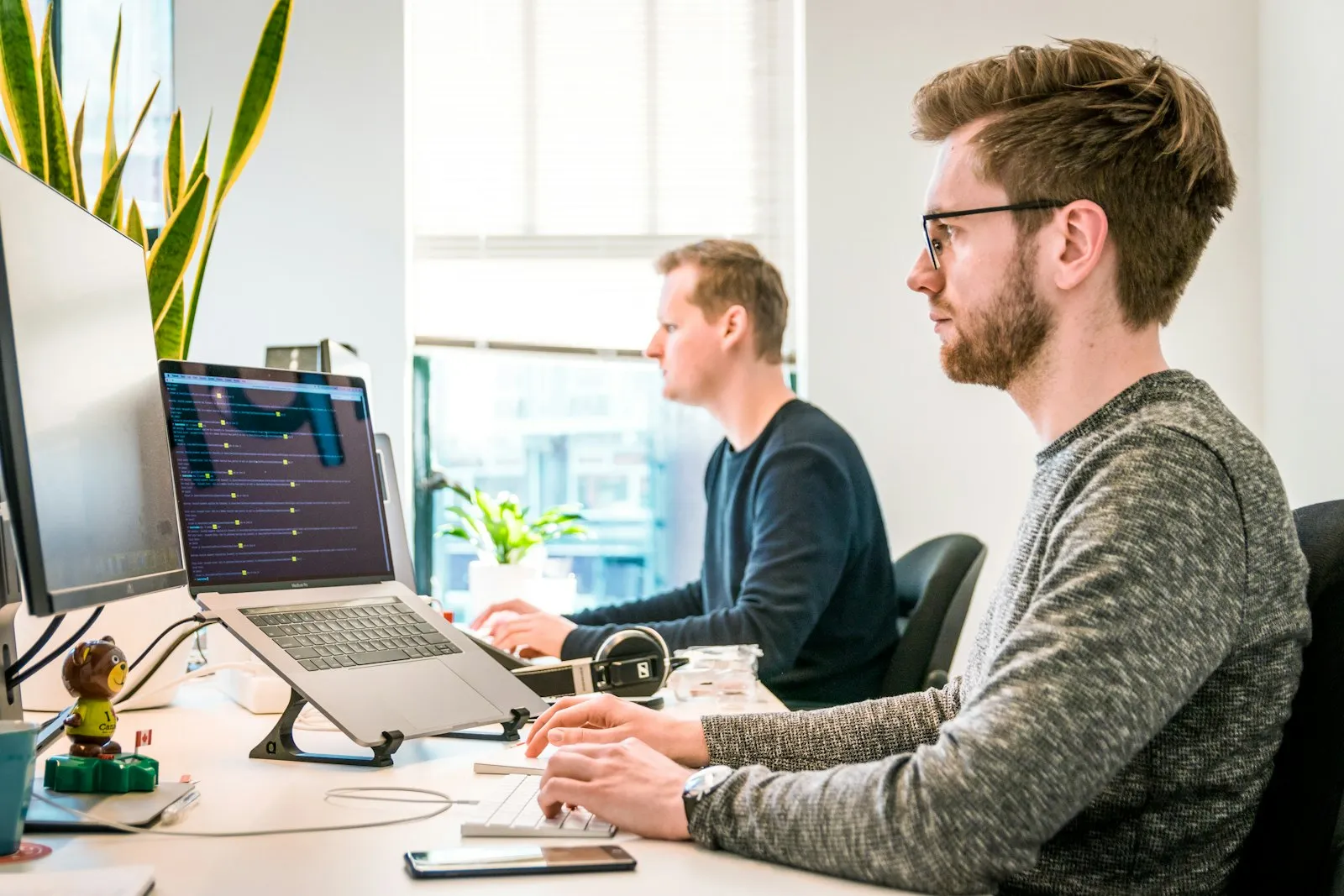 Zwei Kollegen arbeiten an Bildschirmen im Büro